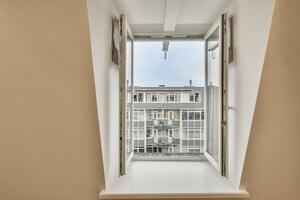 A window with an open door and a view of a building photo