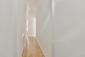 A hallway with white walls and wooden floors photo