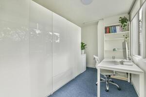 A white office with a desk and a bookcase photo