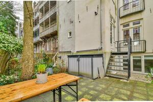 A small patio with a table and chairs in front of a building photo