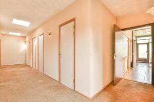 A hallway with a door and a window photo