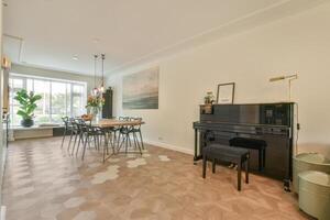 A piano sits in a room with a dining table and chairs photo