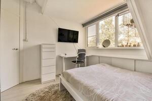 A bedroom with a bed, desk and tv photo