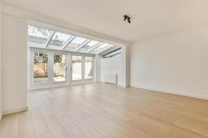 An empty room with a skylight and wooden floors photo
