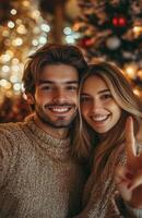 joyful young couple taking a selfie at home, using a smartphone for a call during Christmas photo