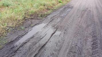 A muddy road with puddles of water on it The road is dirty and wet photo