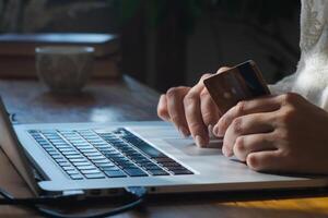 Transfer money online using bank payment card. Hands input credit card data using laptop. photo