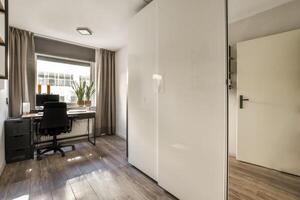 A clean room with a desk and a window photo