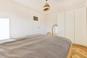 A bed with a gray blanket photo