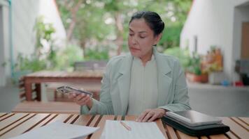 Answering the phone and speaking with dissatisfaction. Frustrated businesswoman dissatisfied with work and answering incoming phone call outdoors. Working on tablet and taking notes. Deadline. Stress. video