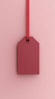 Rectangular red blank paper tag label price tag with hanging satin rope isolated pink photo