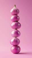 A stack of red onion balancing to top with solid bacground photo
