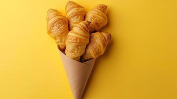 Croissant wrapped on brown paper cone wrapped copy space background photo
