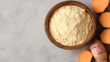 Sweet potato flour on brown wooden bowl and some seeds for baking, gluten free copy space photo