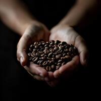Hands holding coffee beans on a black background photo