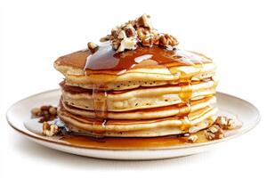 A stack of pancakes with syrup and pecans photo