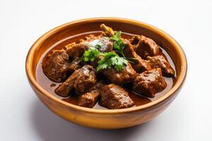 Indian beef curry in a wooden bowl on a white background photo