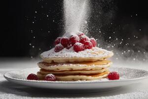 A stack of pancakes with powdered sugar and raspberries photo