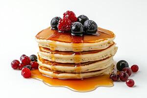 A stack of pancakes with berries and syrup photo