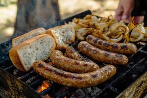 Sausages on a grill with bread and onions photo