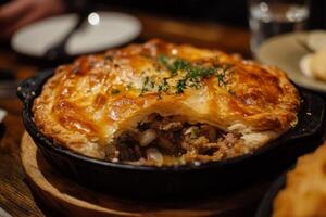 A meat pie sitting on top of a wooden table photo