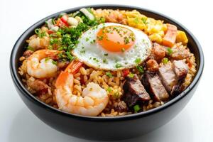 A bowl of rice with shrimp, pork and an egg photo