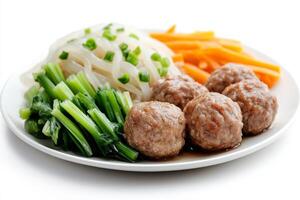A plate with meatballs, carrots and green onions photo