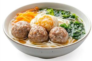 A bowl of noodles with meatballs and vegetables photo