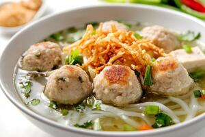 A bowl of soup with meatballs and noodles photo