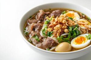 A bowl of noodles with meat, eggs and vegetables photo