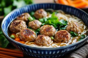 Chinese meatball soup with noodles and carrots photo