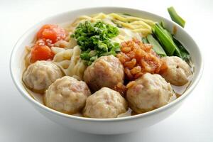 A bowl of noodles with meatballs and vegetables photo