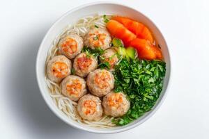 A bowl of noodles with meatballs and vegetables photo