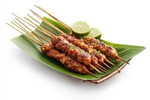 A plate with several skewers of meat on a leaf photo