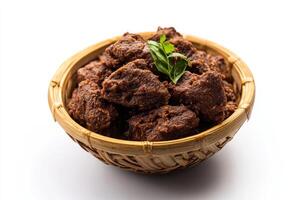 A bowl filled with meat and herbs on a white background photo