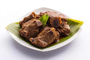 A plate of meat with green leaves on it photo