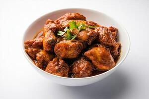 Chicken wings in curry sauce in a white bowl photo
