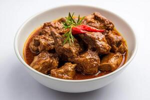 A bowl of meat and spices on a white table photo