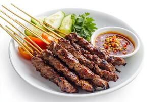 Thai beef satay on a white plate with sauce photo