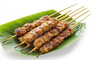 A plate of meat skewers on a leaf photo