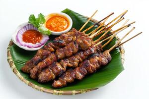 A plate with skewers of meat and sauce photo