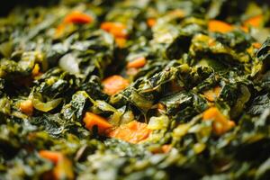 A close up of a bowl of greens with carrots photo