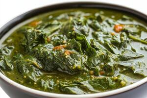 A bowl of spinach with a spoon in it photo