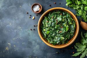 Spinach with herbs and spices in a bowl on a dark background photo