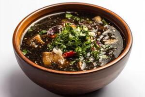 A bowl of soup with meat and herbs photo