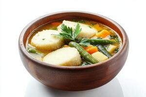 A bowl of soup with dumplings and vegetables photo