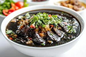 A bowl of black bean soup with meat and herbs photo