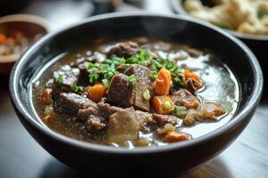 A bowl of beef stew with vegetables and other food photo