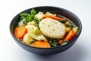A bowl of soup with vegetables and dumplings photo