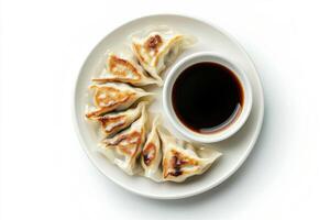A plate with dumplings and sauce on a white background photo